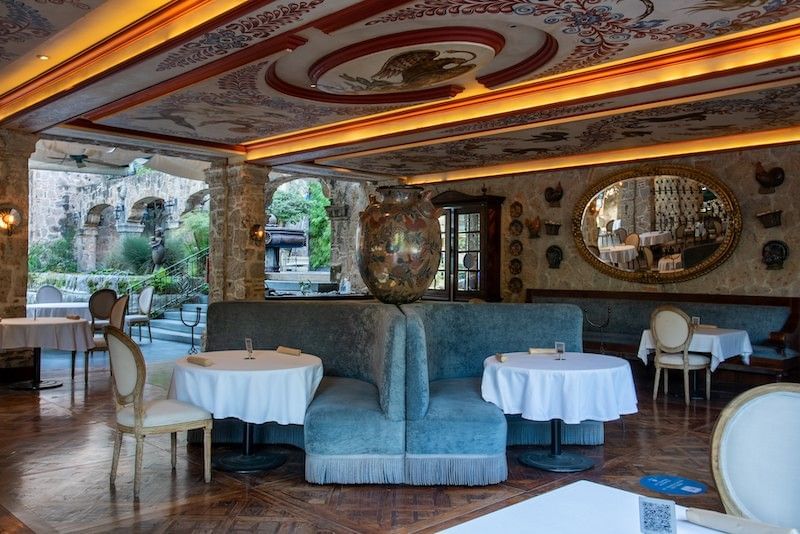 Blue booths by tables under a painted ceiling in the elegant restaurant at Camino Real Pedregal Mexico