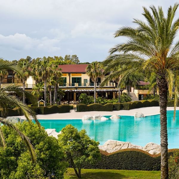 Outdoor pool area with palm trees Falkensteiner at Club Funimation Garden Calabria