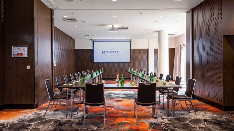 U-shaped table setup facing the projector screen in The Hunter Room 4 at Novotel Sydney on Darling Harbour
