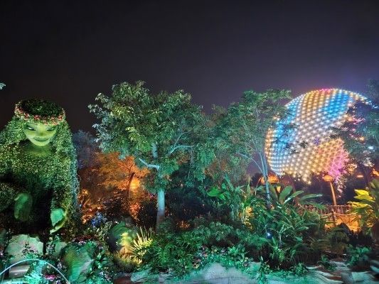 A night sky reflecting the vibrant colors of the Journey of Water, Inspired by Moana experience at Walt Disney World's EPCOT theme park near Rosen Inn at Pointe Orlando, a budget-friendly hotel near Orlando's theme parks.