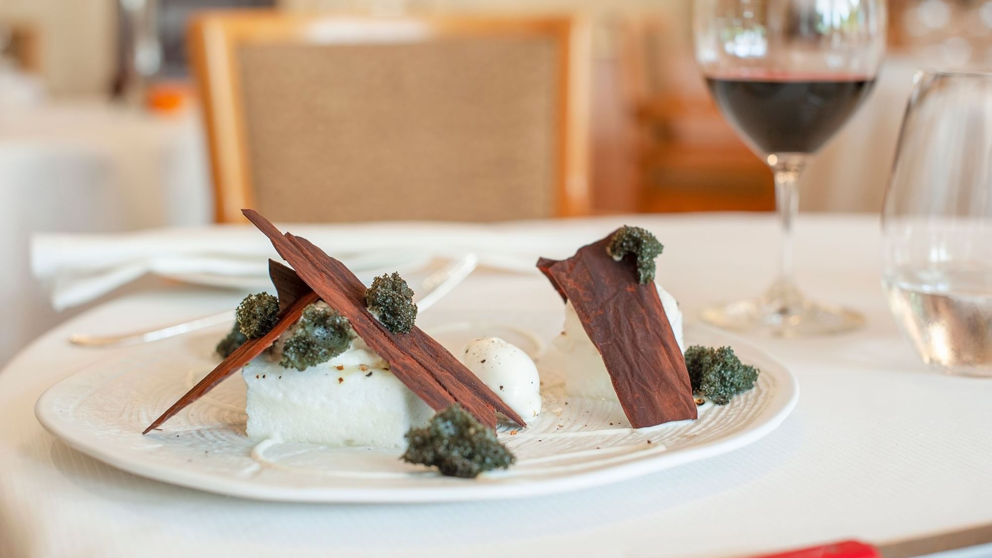 Closeup on a dish served with red wine at Originals Hotels