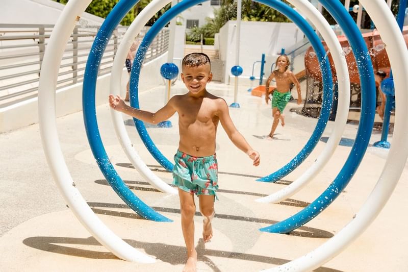 A kid playing by the Splash Pad at The Diplomat Resort