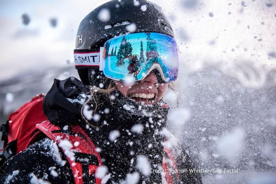 Portrait of a woman in snow gear with goggles and a helmet near Blackcomb Springs Suites