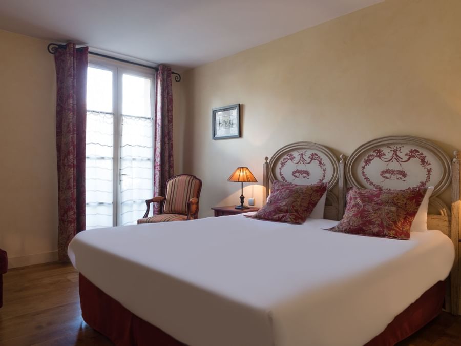 Comfy bed in a room at Hotel Aux Vieux Remparts