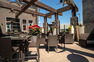 Outdoor patio dining area with wicker furniture Chop Steakhouse & Bar at Sandman Hotel & Suites Winnipeg Airport