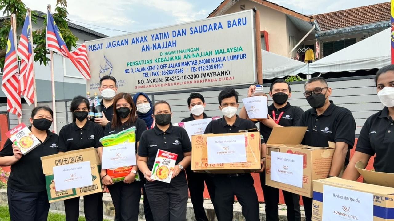 Group of people posing with boxes in their hands at Sunway Putra Hotel