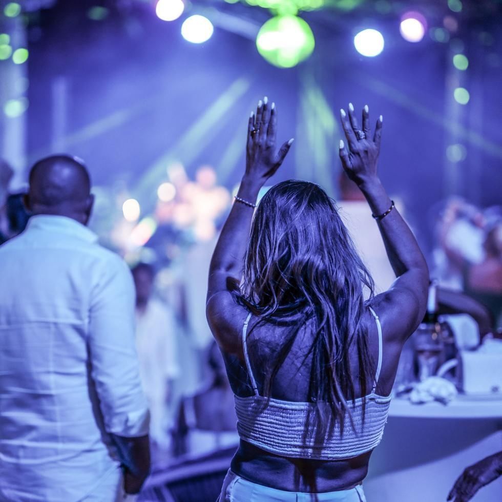Woman dancing with raised arms at the Burning Lederhos'n Festival.