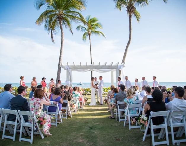 People at a wedding ceremony in Copa garden at Copamarina