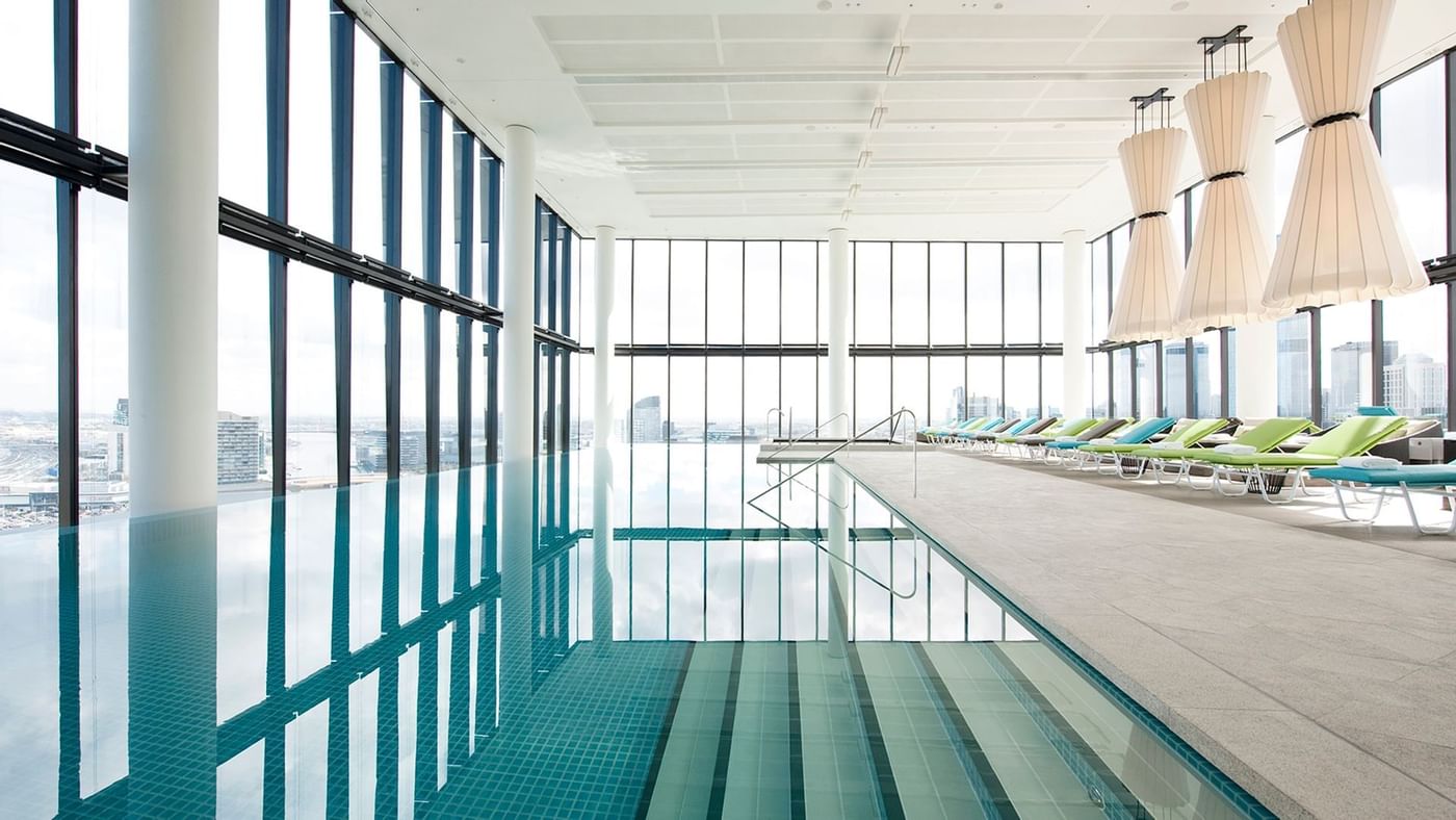 Indoor pool with lounge chairs at Crown Hotels