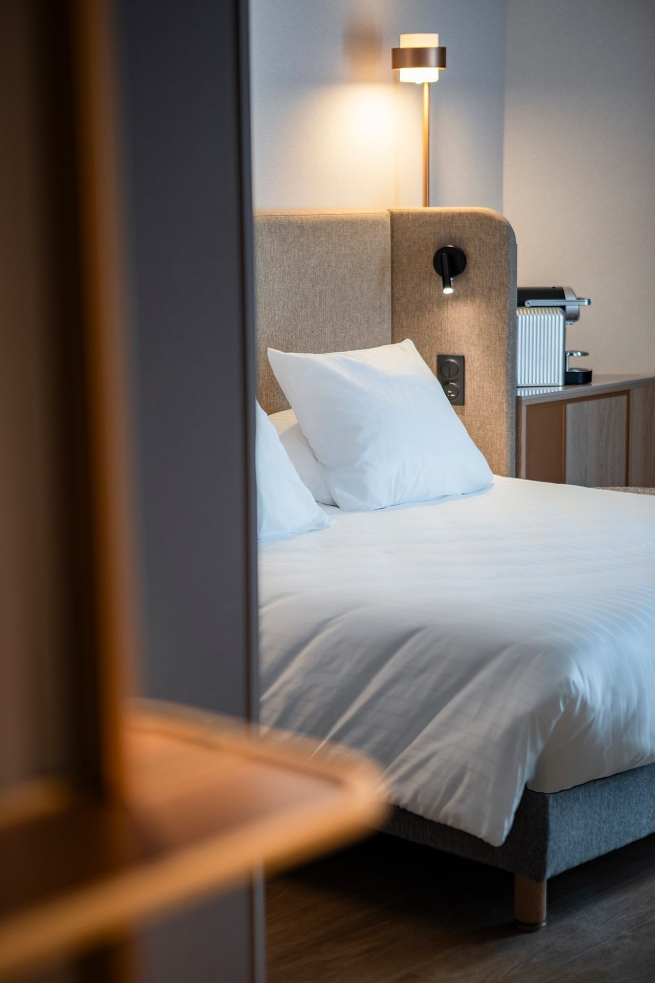 Gros plan sur un appuie-tête avec une lampe de chevet dans une chambre à l'Oceania Saint-Malo