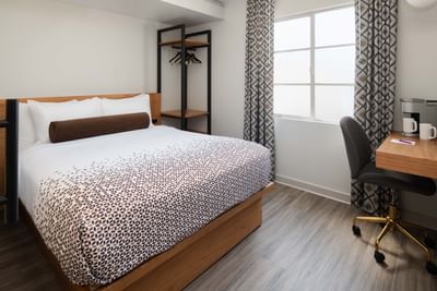 Cozy Room with a bed by a black open closet and a patterned curtain near the window at Hotel Keen