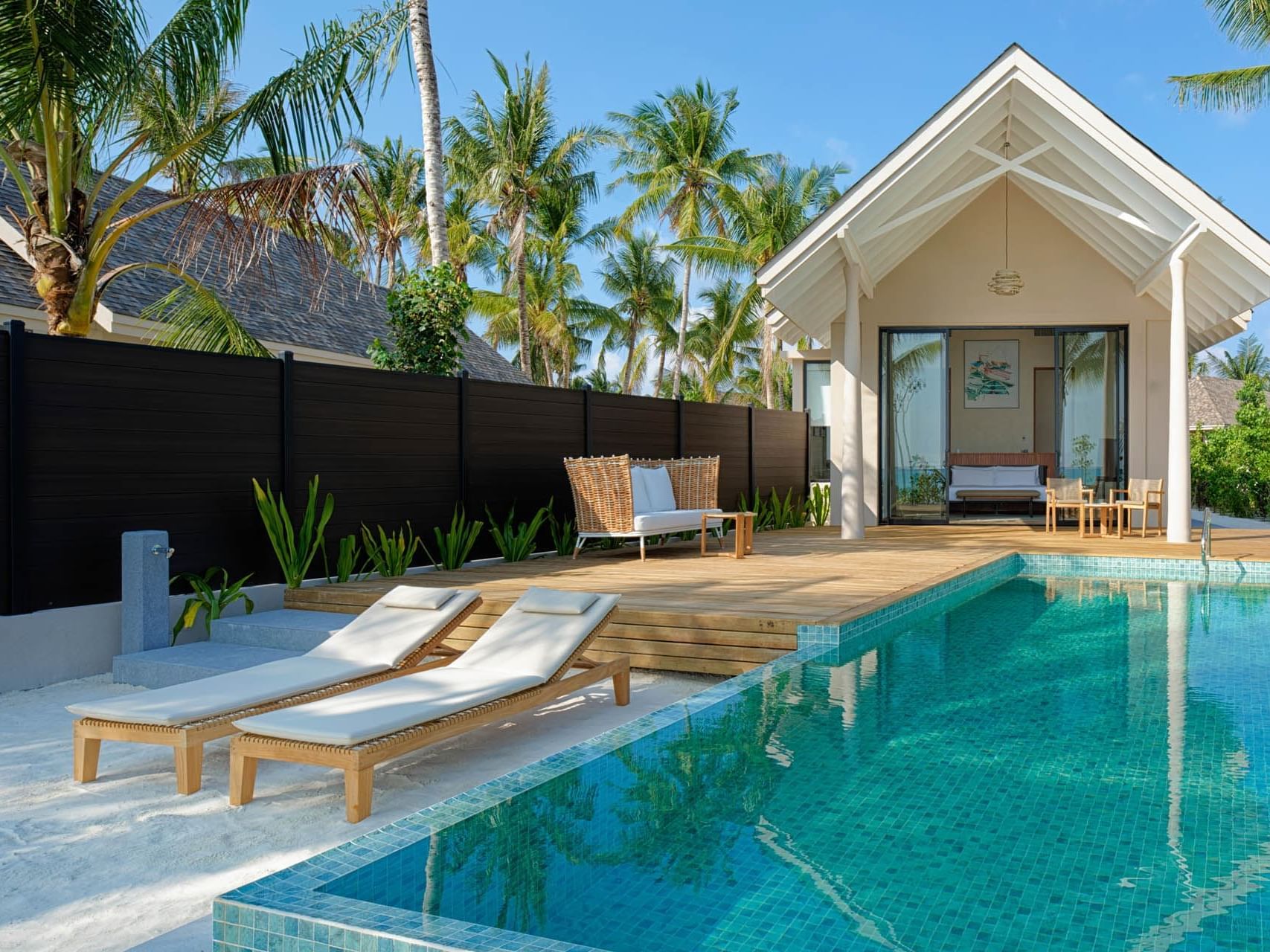 Serene poolside scene with two lounge chairs and a wooden deck at Beach Pool Villas in Ananea Madivaru Maldives