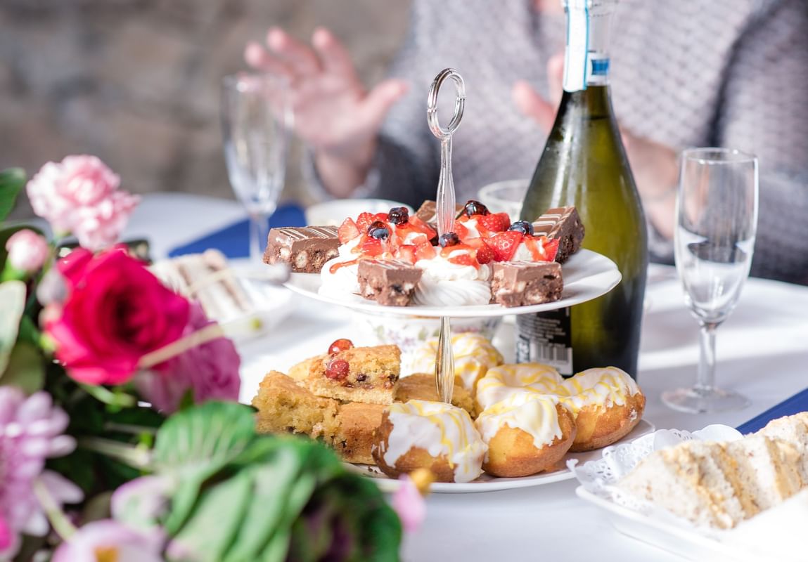 Close-up of table setting with desserts, wine, and flowers at Warwick Allerton Chicago