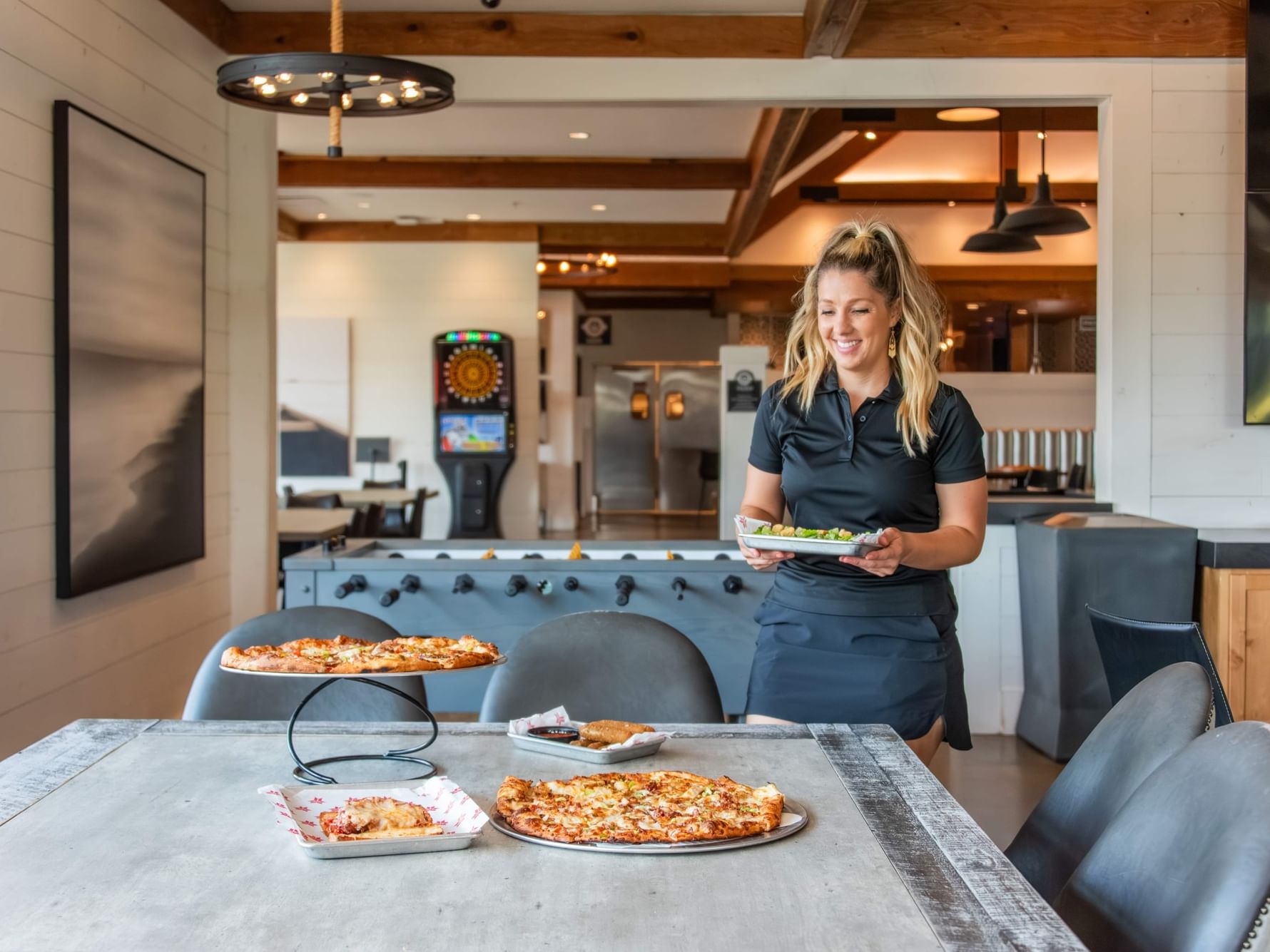 Woman serving pizza at Anchor Crust Co. restaurant at Shangri-La Resort