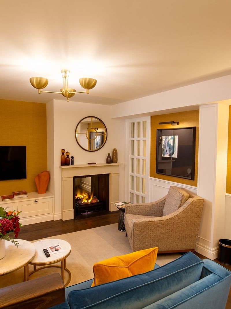 Hyde Park Suite TV lounge with plush sofas near the fireplace at The Capital Hotel, Apartments and Townhouse