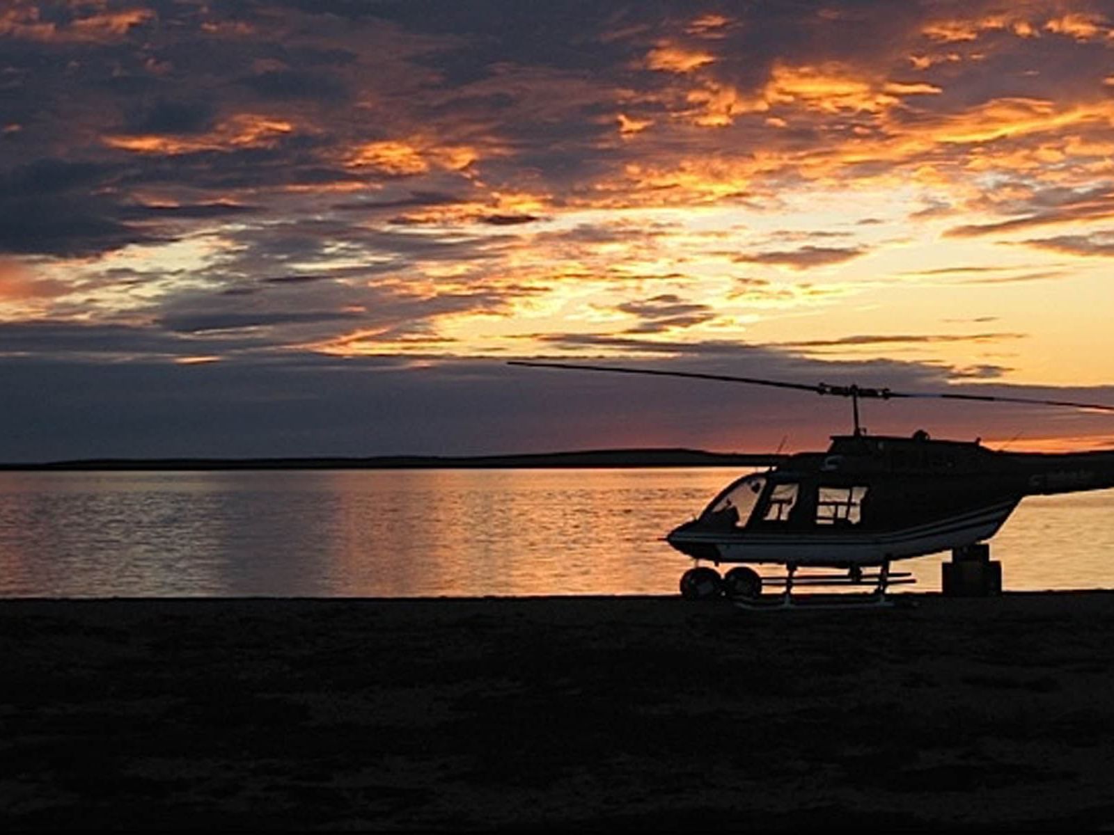 Un helicóptero aparcado a la playa. 
