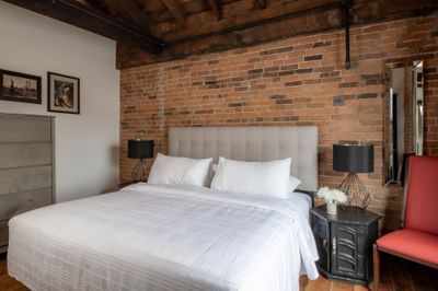 King bed, nightstand & chair in Apartment 404 at Retro Suites Hotel