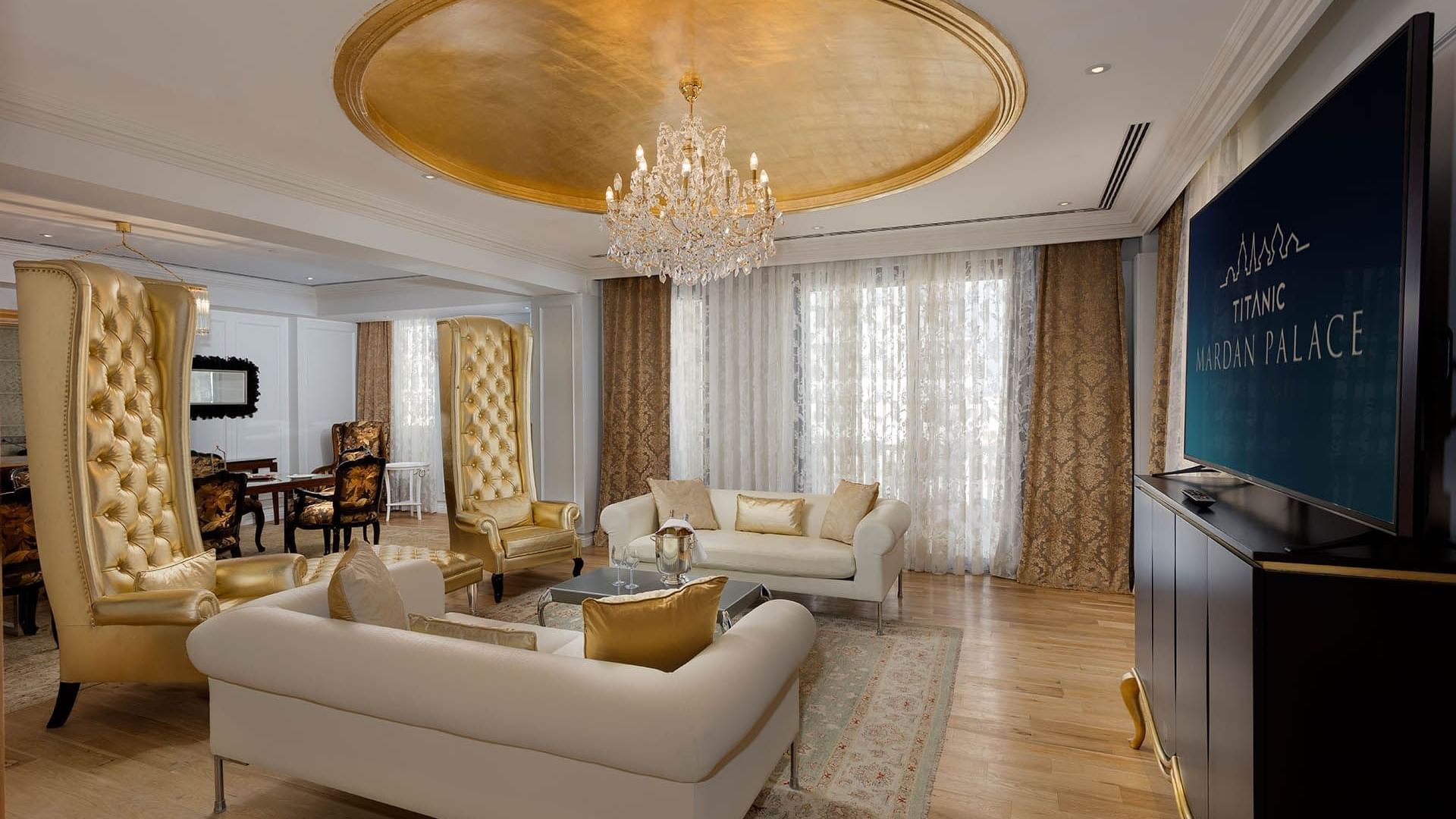 Просторная гостиная в президентском люксе отеля Titanic Mardan Palace с удобными креслами и телевизором