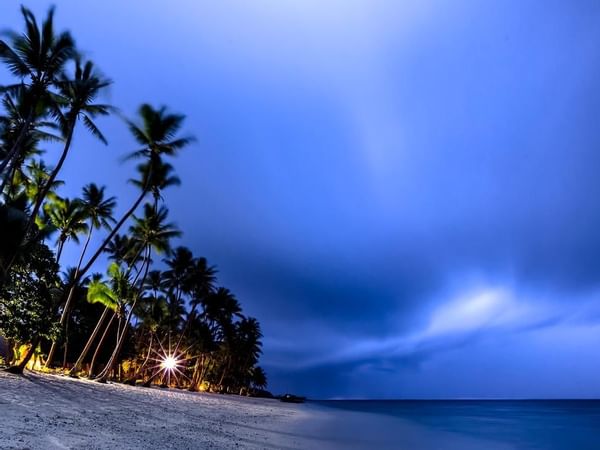The landscape of the beach at night at Tambua Sands Resort