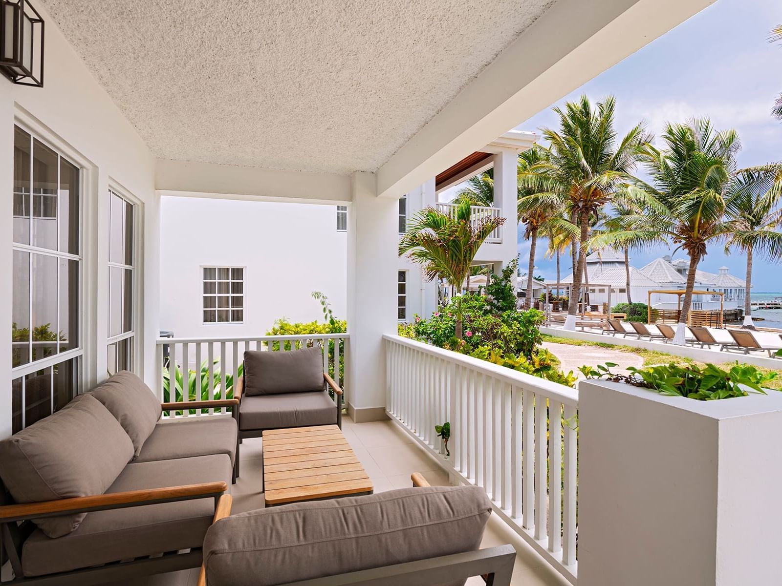 Outdoor balcony area with couches in Oceanfront Reef House 2 Bedroom Suite at Alaia Belize Autograph Collection