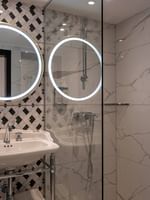 Luxe badkamer met ronde spiegels en marmeren tegels in Deluxe Kamer, Hotel Barsey by Warwick, Brussel