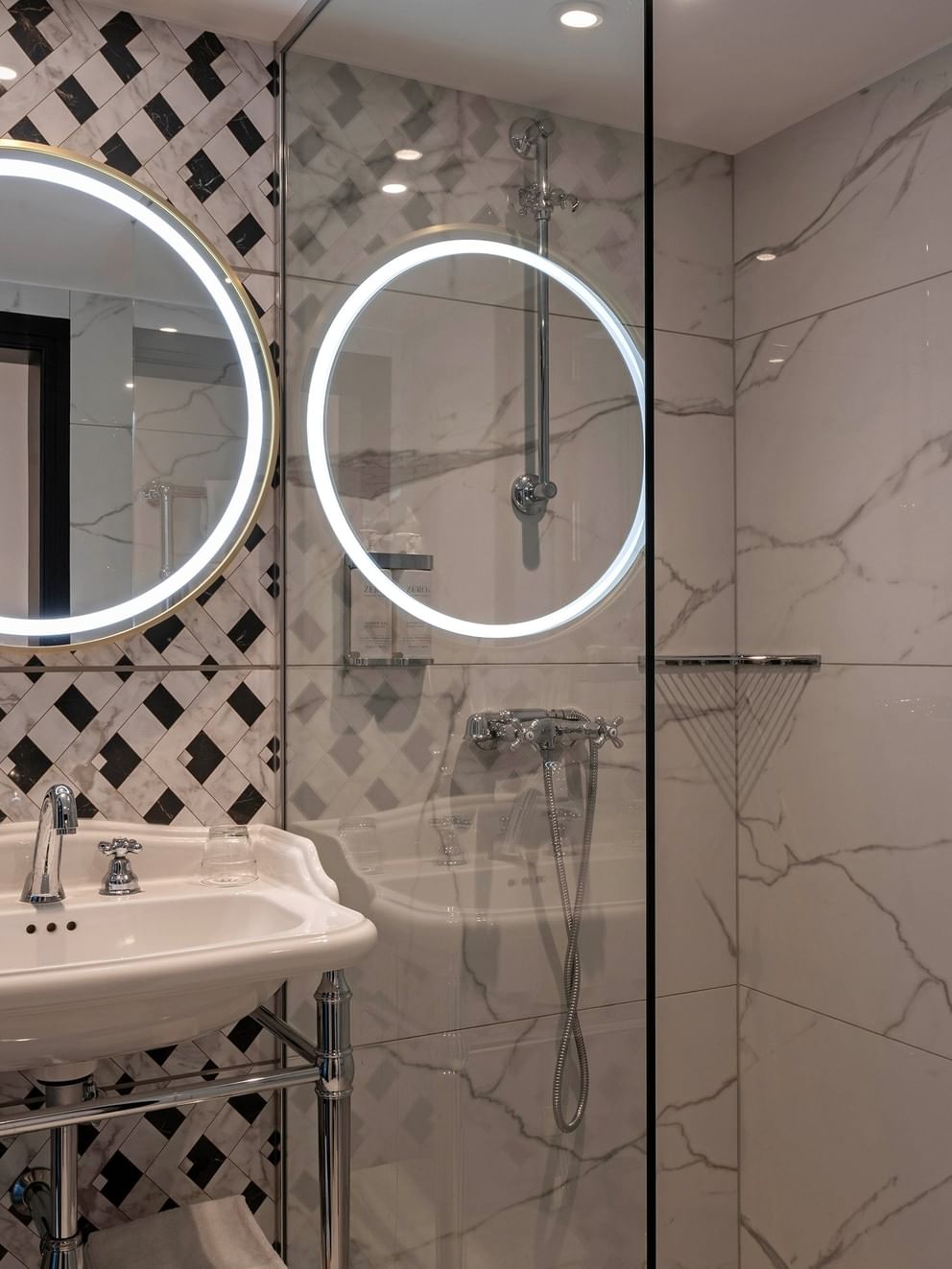 Luxe badkamer met ronde spiegels en marmeren tegels in Deluxe Kamer, Hotel Barsey by Warwick, Brussel