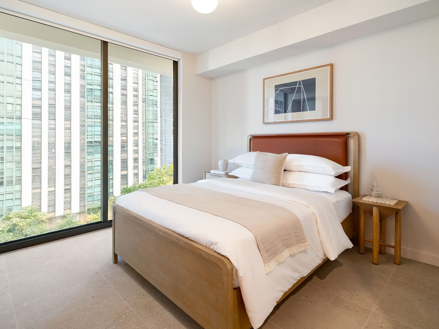 Bed between the side table near the window in the Accessible Studio Queen at The Crosby Miami World Center
