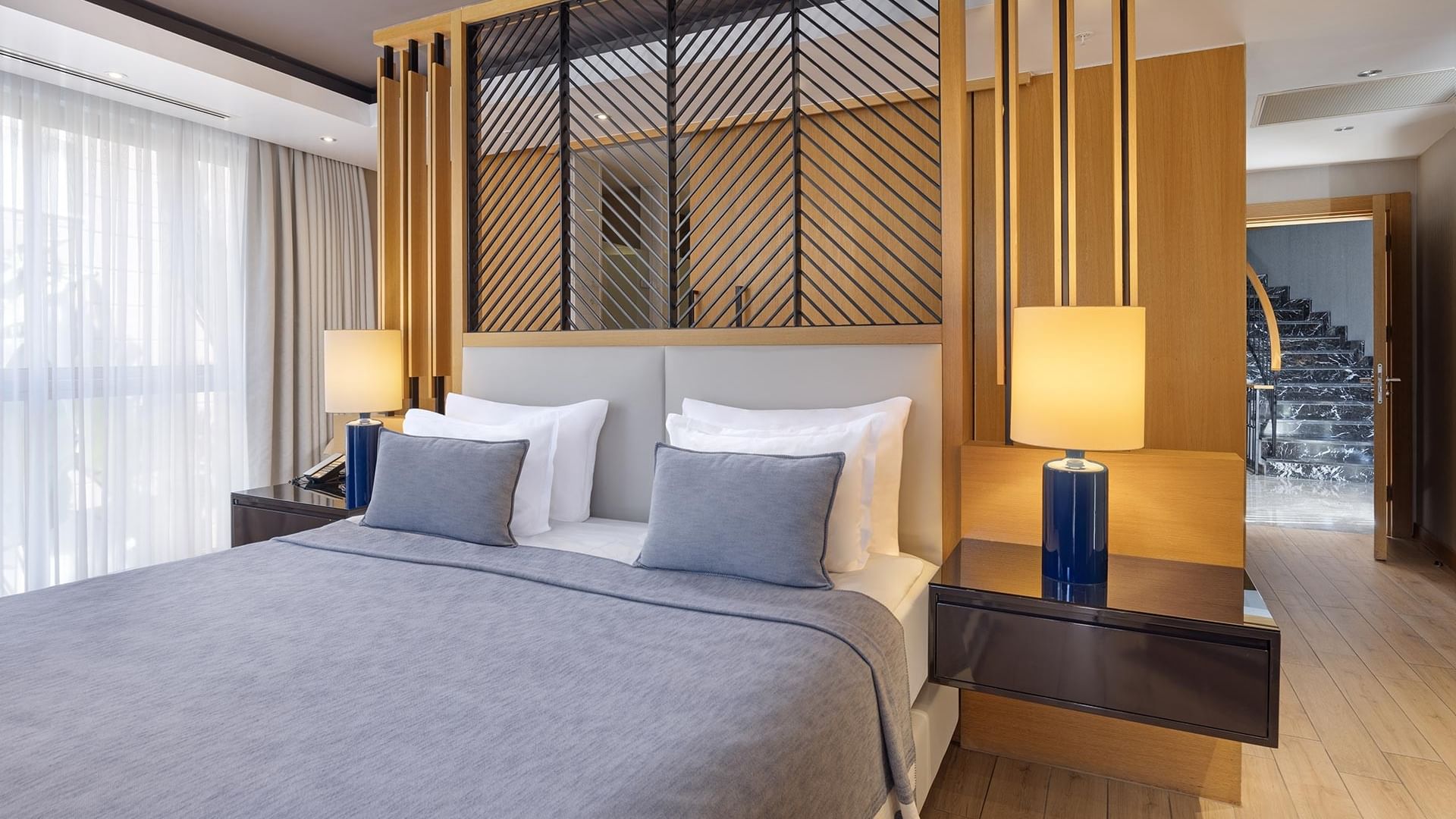 Роскошная спальня виллы Superior в Titanic Luxury Collection Bodrum с большой кроватью, качественным постельным бельём и двумя прикроватными тумбами.