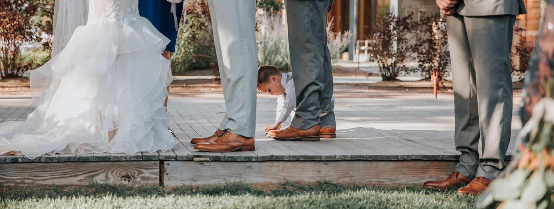 Wedding ceremony at Topnotch Resort with a child crawling under the wooden deck. Photo Credit: Savannah Brown