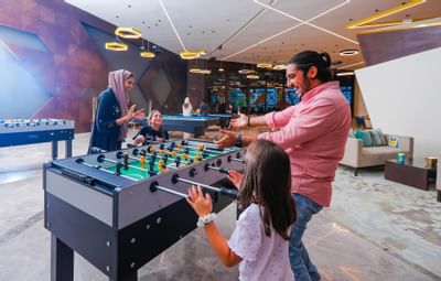 A family playing foosball at Bay La Sun Hotel & Marina