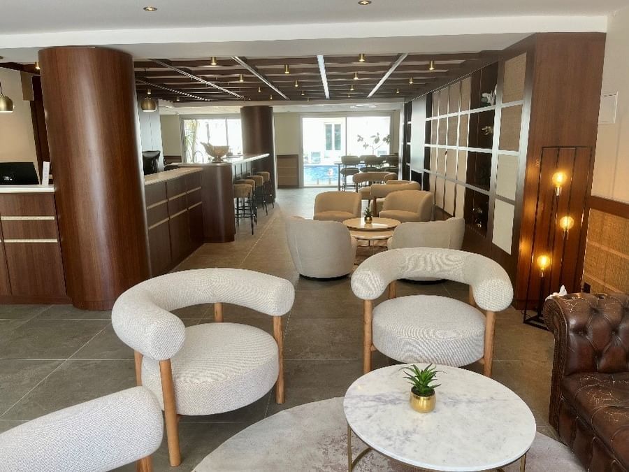 Salon élégant avec fauteuils et comptoir de réception de l'Hôtel Le Yachtman.