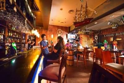 Cozy bar setting with guests enjoying drinks at Lanun Restaurant & Bar - Grand Lexis Port Dickson