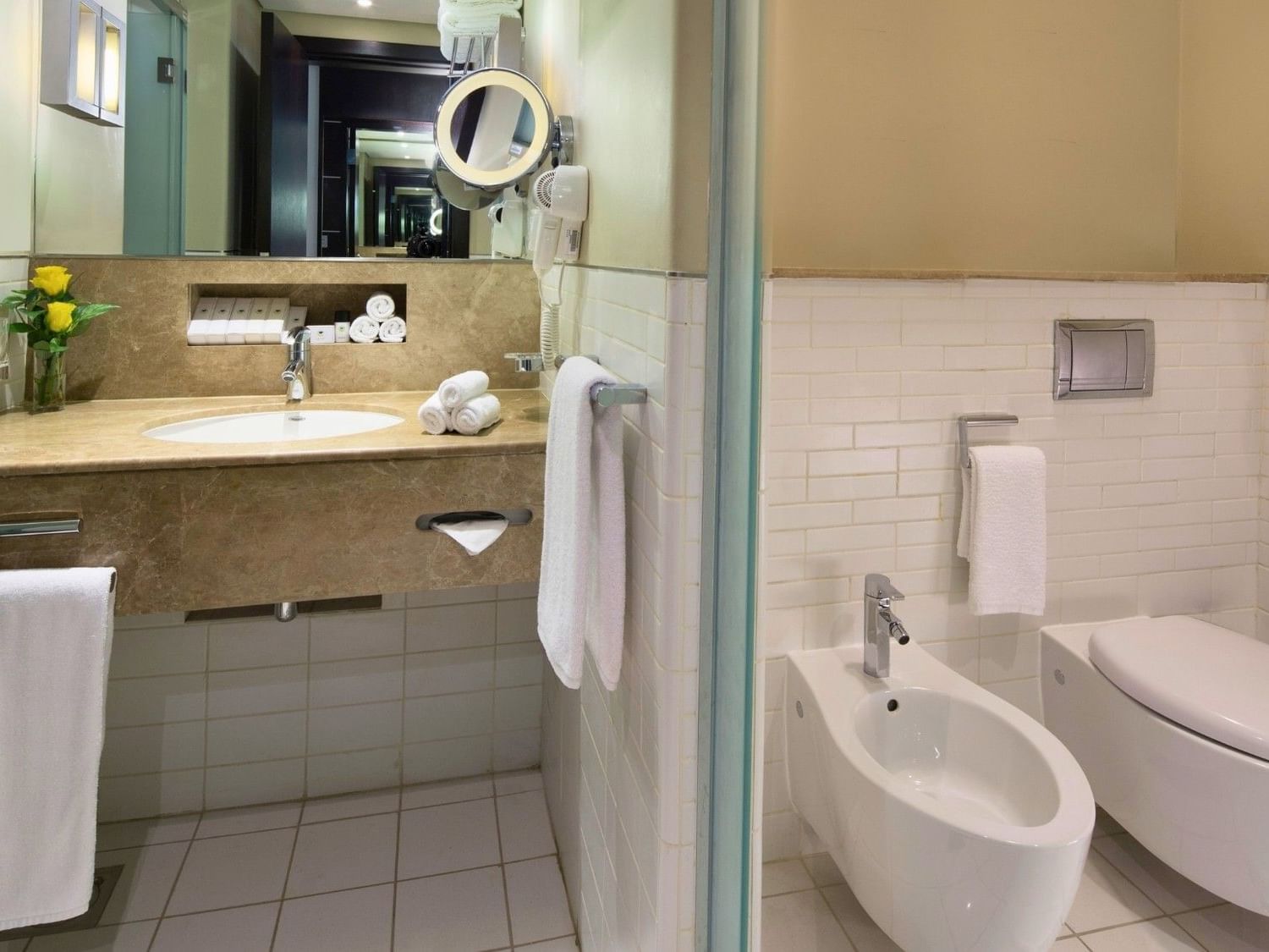 Folded towels on the bathroom counter in Deluxe Room at Dubai International Hotel