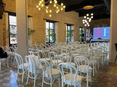 Elegantly event space with chairs, large screen displaying