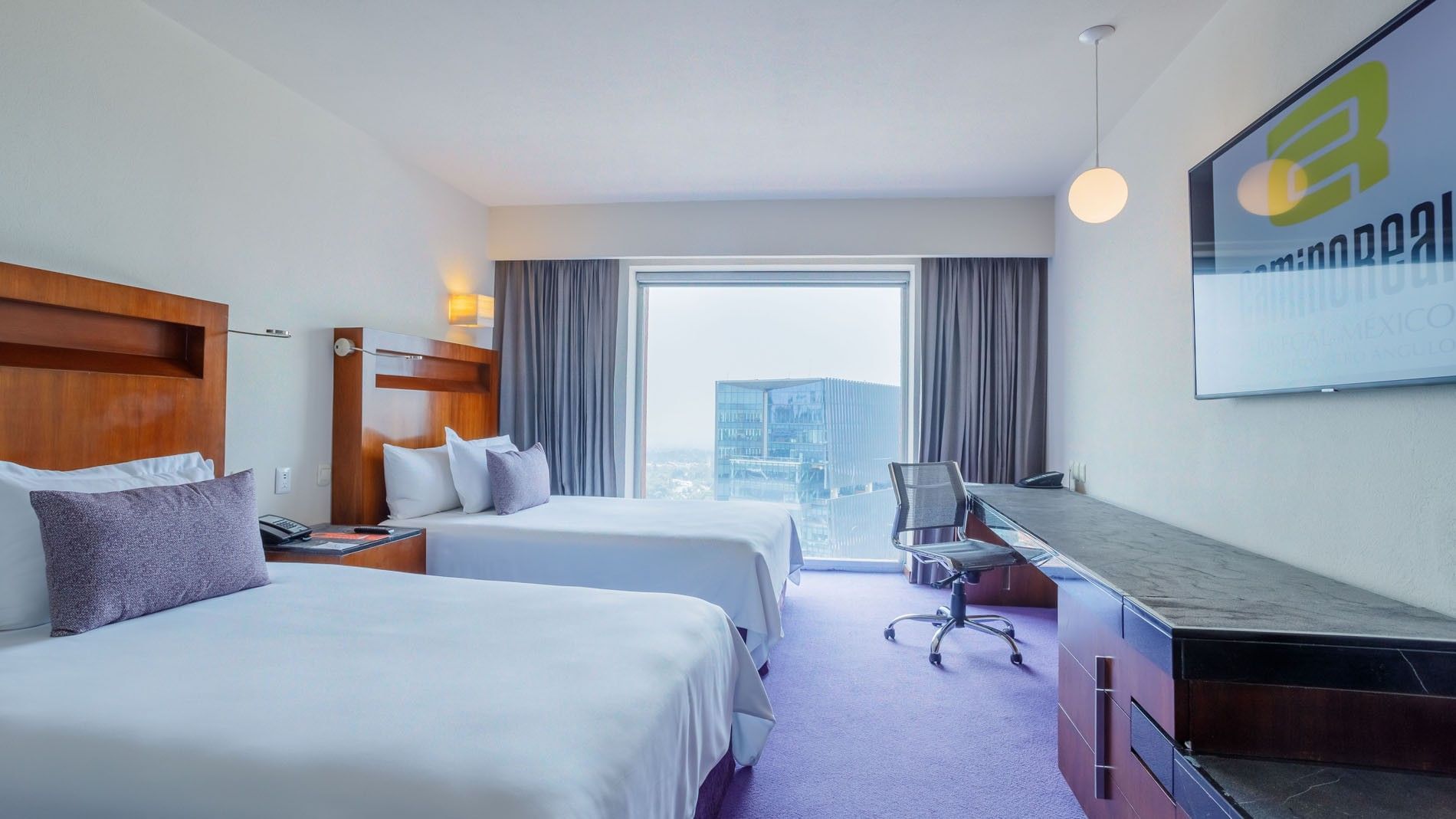 Contemporary 2 Double Deluxe room at Camino Real Pedregal Mexico, showing a large window and city building view