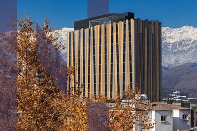 Distant exterior view of Hotel Nodo and the city with a snowy mountain backdrop