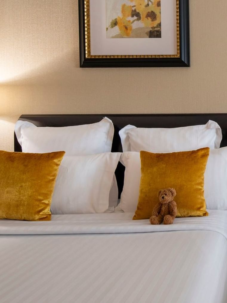 Chambre familiale avec deux lits queen size, un coin salon et des rideaux à l'hôtel Warwick Champs-Élysées à Paris.