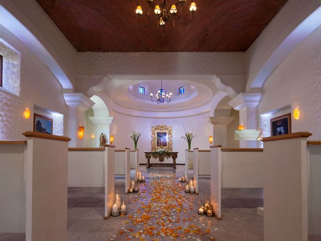 Espacio interior para ceremonias de boda en capilla en Hacienda del Mar Los Cabos con un camino de pétalos de rosa y velas