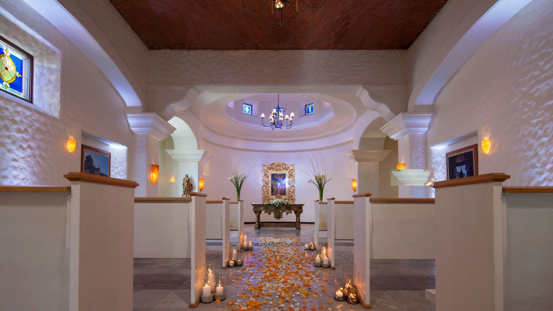 Espacio interior para ceremonias de boda en capilla en Hacienda del Mar Los Cabos con un camino de pétalos de rosa y velas