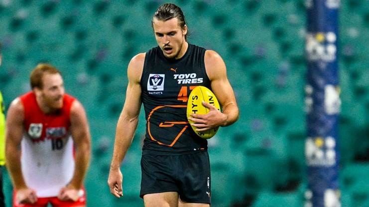 Male AFL player holding a yellow ball during an AFL Giants game near Novotel Sydney Olympic Park