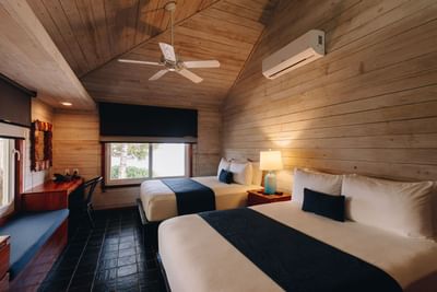 Two Bedroom Oceanfront Villa with two beds and wood paneled walls at Barefoot Cay Resort & Marina