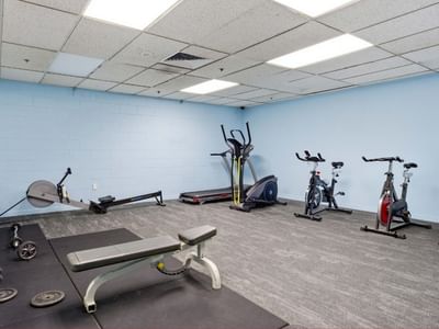 Exercise room with various fitness equipment and weights at UniLodge Stafford House.