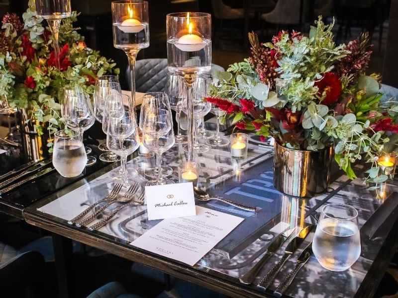 Dining table setup with candles, glassware, and a floral centerpiece in Prive at Sofitel Brisbane Central