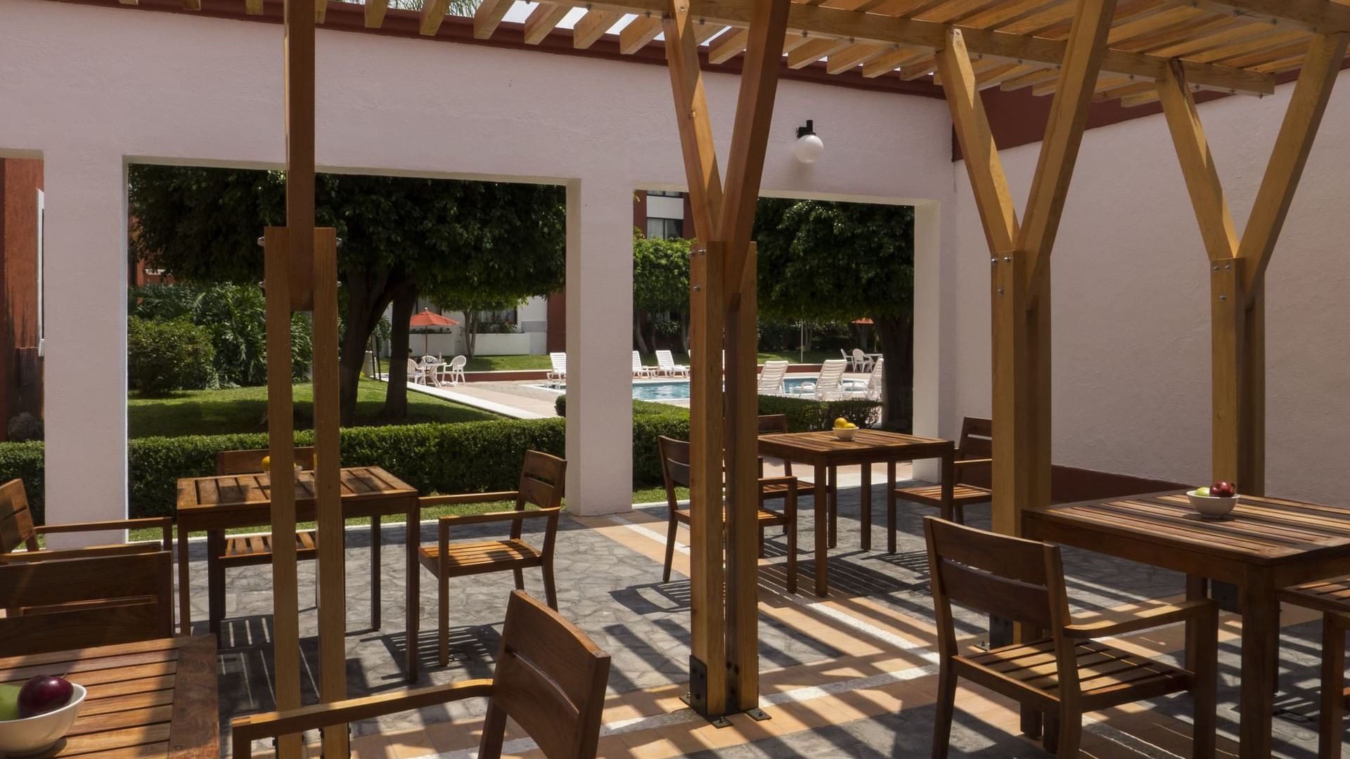 An outdoor dining area near the outdoor pool at Fiesta Inn León