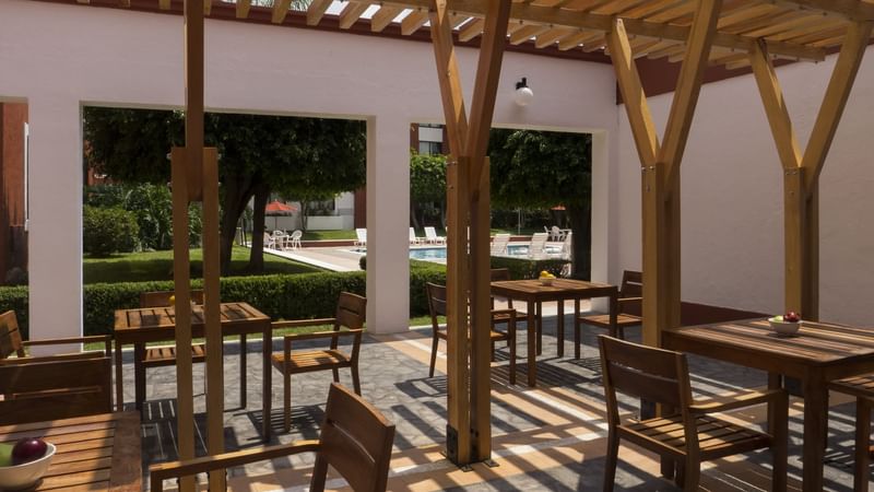 An outdoor dining area near the outdoor pool at Fiesta Inn León