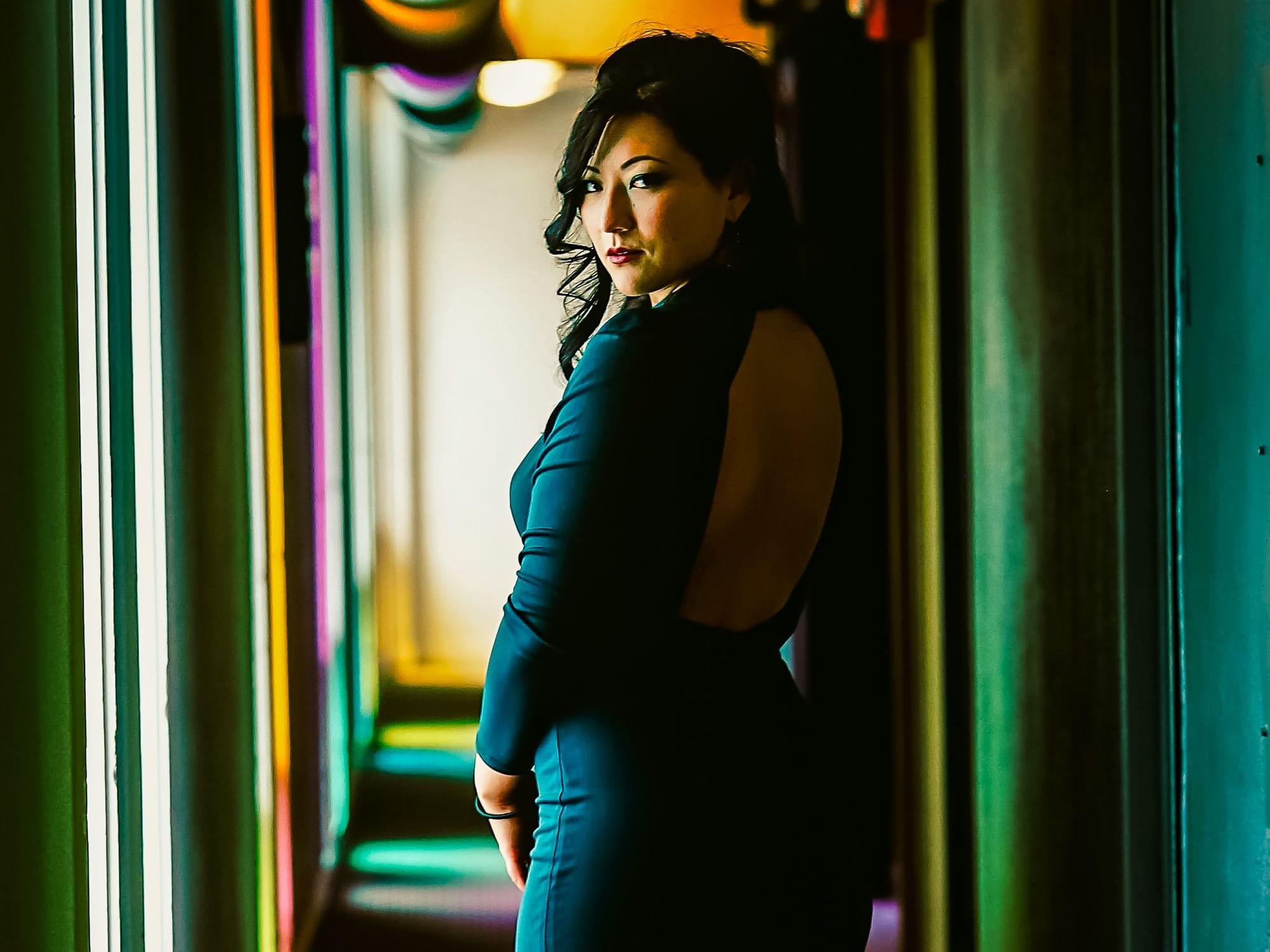 Woman posing by amplified room hallway at The Verb Hotel