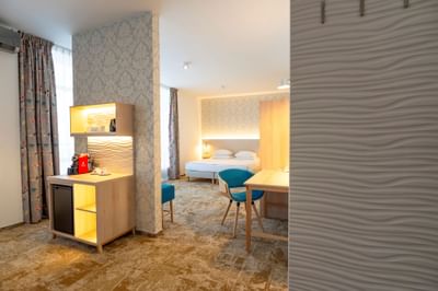 Junior Suite with bed, desk, chairs, and coffee station at Metropol Hotel
