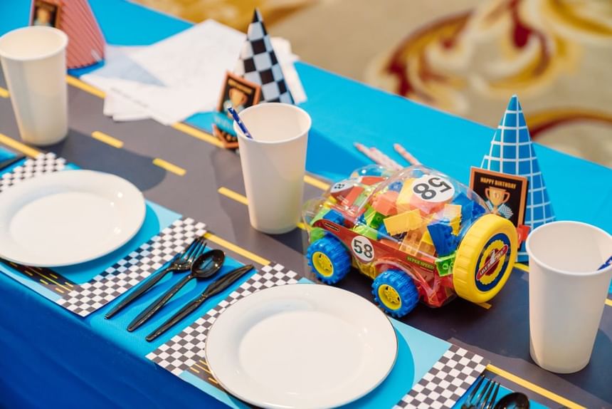 Birthday table set with race-themed decorations, toy car, plates, cups, and utensils at Park Hyatt Saigon