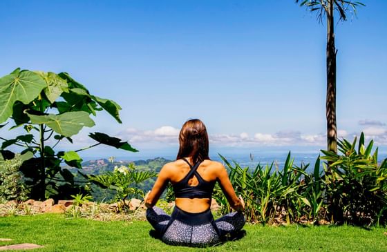 woman sitting doing meditation with mountain view