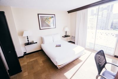 A bed, chair & lamps in Boutique Queen at Stay Hotel Waikiki